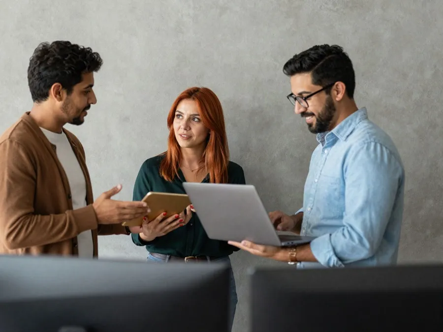 Equipo de trabajo conversando con una tablet y una laptop, en referencia al cuidado de la información